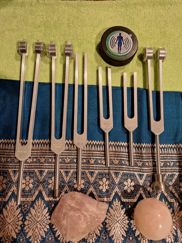 Biofield Tuning therapeutic tuning forks laid out with rose quartz